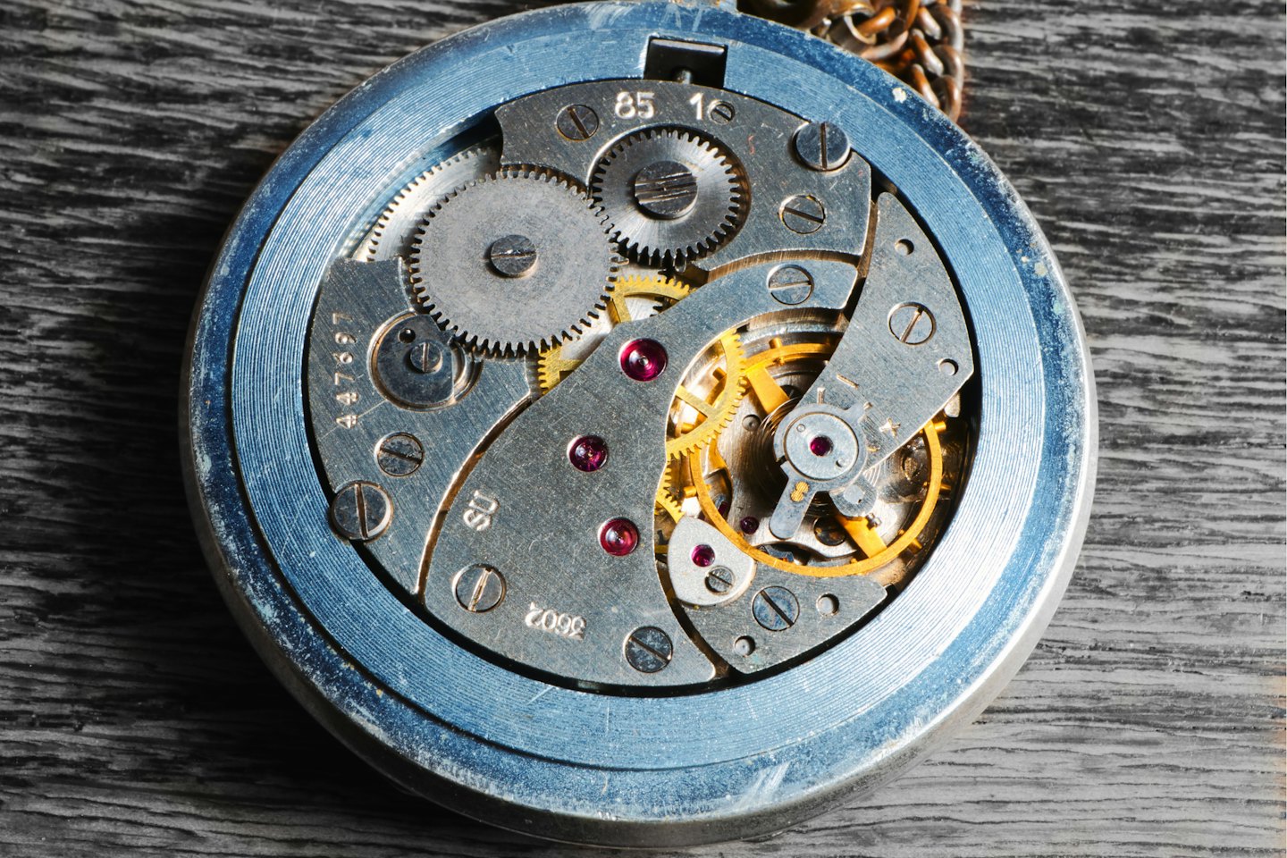 Feine Zahnräder und Juwelen im Inneren einer offenen antiken Taschenuhr.
