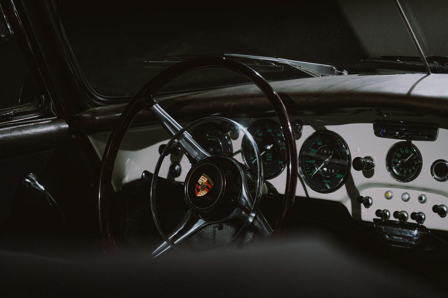 Armaturenbrett eines Oldtimers mit Holzlenkrad und Chrominstrumenten.